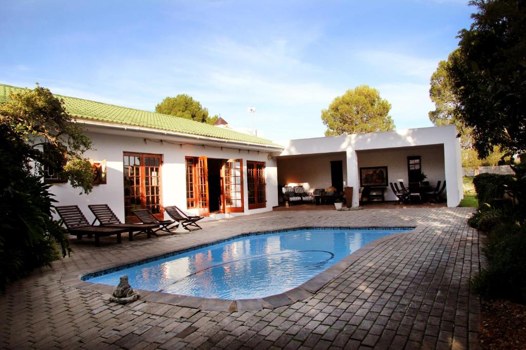 
a large white swimming pool in front of a house at Fynbos Guest House Riversdale in Riversdale
