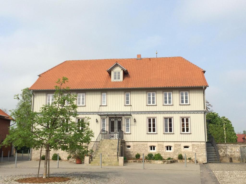 ein großes weißes Haus mit orangefarbenem Dach in der Unterkunft Hotel Garni Demmel & Cie in Rohrsheim