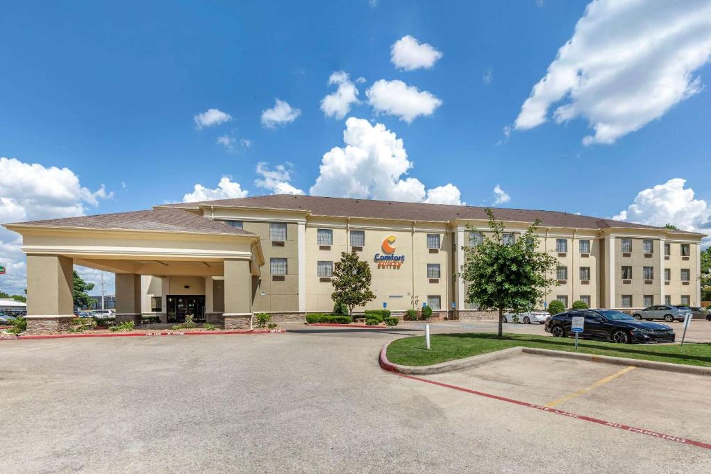 un hotel con un estacionamiento delante de él en Comfort Suites Shreveport West I-20, en Shreveport