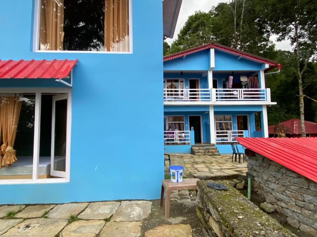 uma casa azul com um telhado vermelho em JAYANTI MOTHER NATURE HOMESTAY MUNSYARI em Munsyari