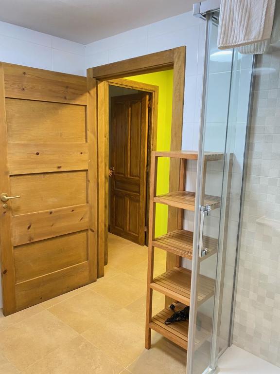 a room with a wooden door and a glass shelf at Apartamentos Playa Galizano in Galizano
