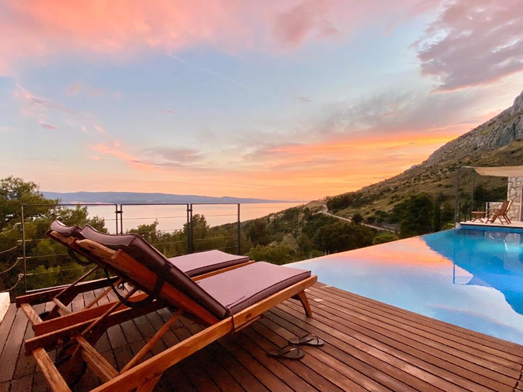 een ligstoel op een terras naast een zwembad bij Villa FORTE-Exclusive location with fantastic seaview & infinity pool - up to 8 Pax in Mimice
