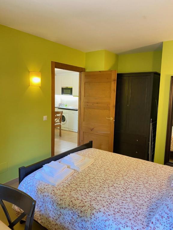 a bedroom with a bed in a room with green walls at Apartamentos Playa Galizano in Galizano
