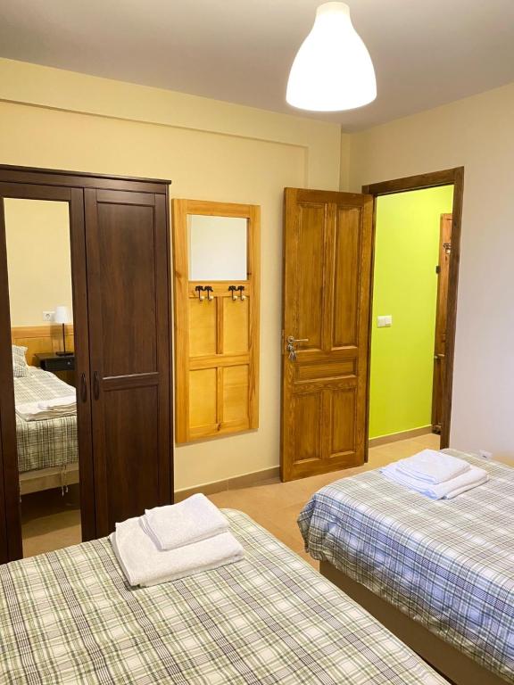 a bedroom with two beds and a closet and a mirror at Apartamentos Playa Galizano in Galizano