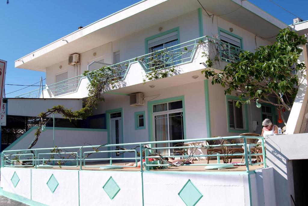 a building with a balcony with a woman on it at Marianthi Studios Stegna in Archangelos