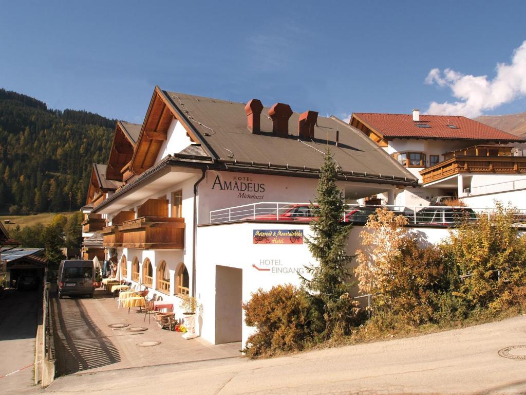 a large white building with a train on top of it at Hotel Amadeus Micheluzzi in Serfaus
