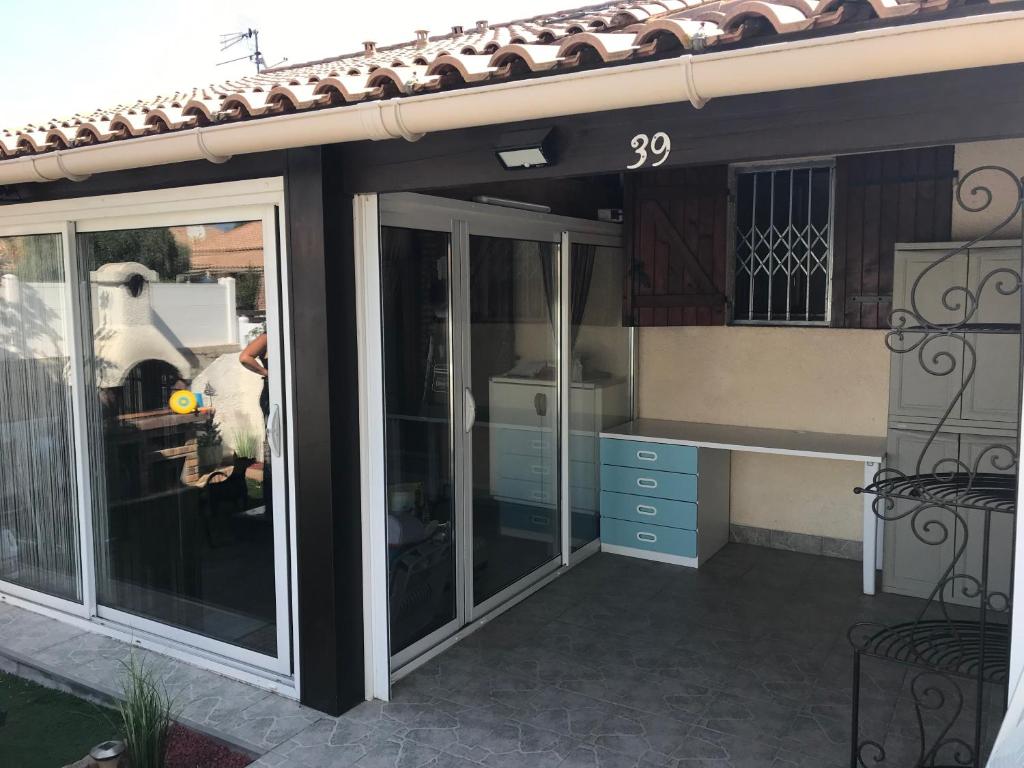 a patio extension with sliding glass doors on a house at Les margouillats - maisonnette à 2 pas de la plage in Vias