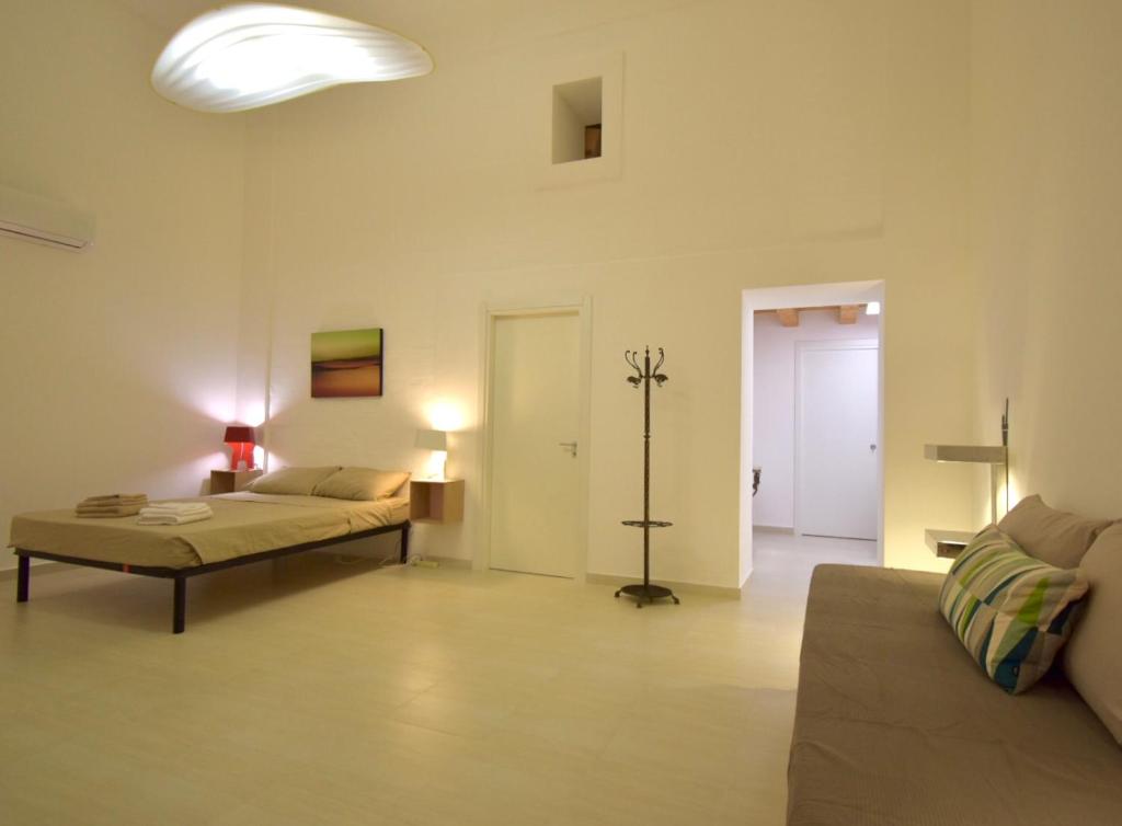 uma sala de estar com duas camas e um sofá em Casa Argento em Sciacca
