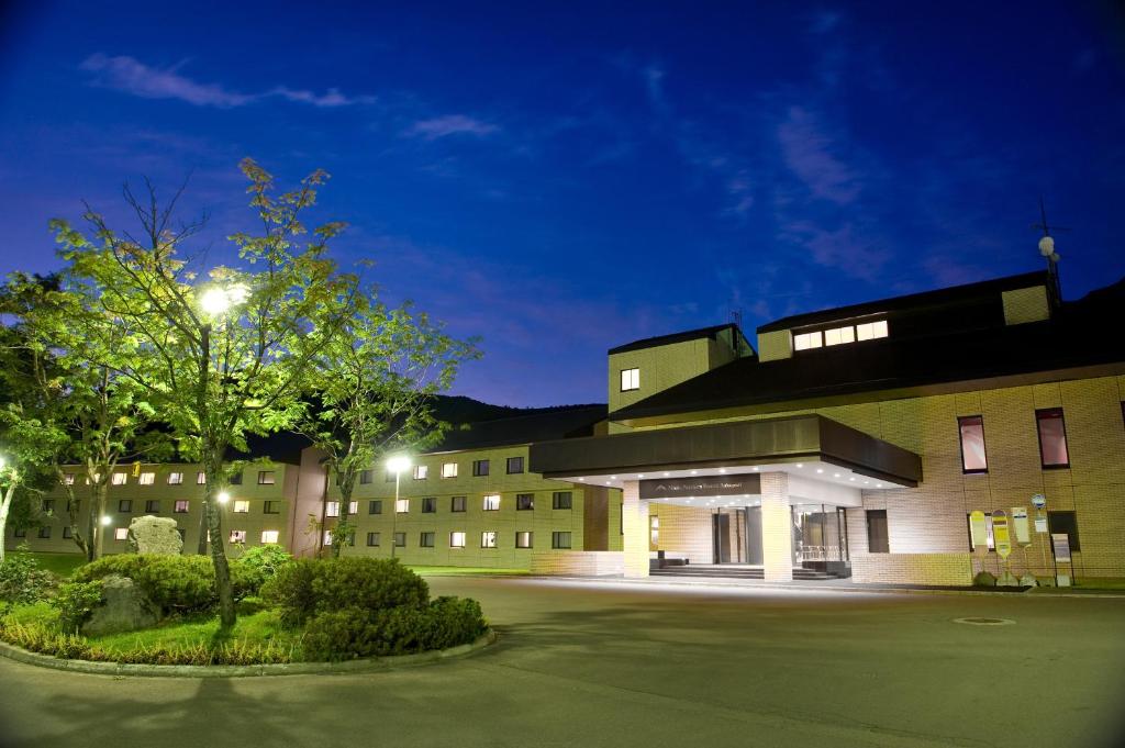 a building with a tree in front of it at night at Niseko Northern Resort, An'nupuri in Niseko