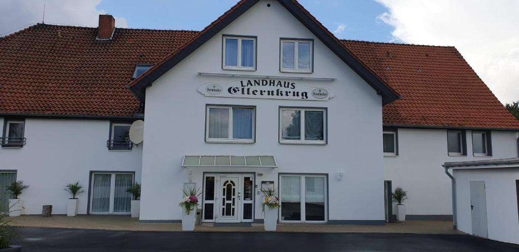 een wit gebouw met een bord waarop Hamlins gedoopt wordt bij Landhaus Ellernkrug Hotel in Lage