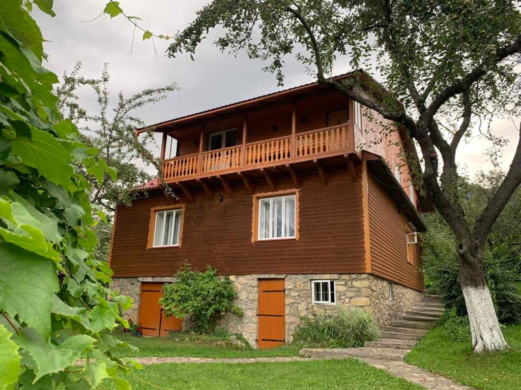 ein Holzhaus mit Balkon darüber in der Unterkunft Приватна садиба Яблуневий сад in Jaremtsche