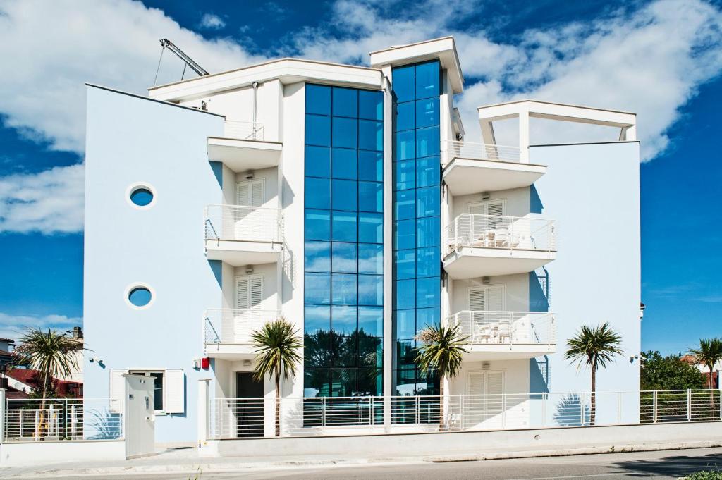 a white building with a glass facade at Mavip Residence in San Benedetto del Tronto