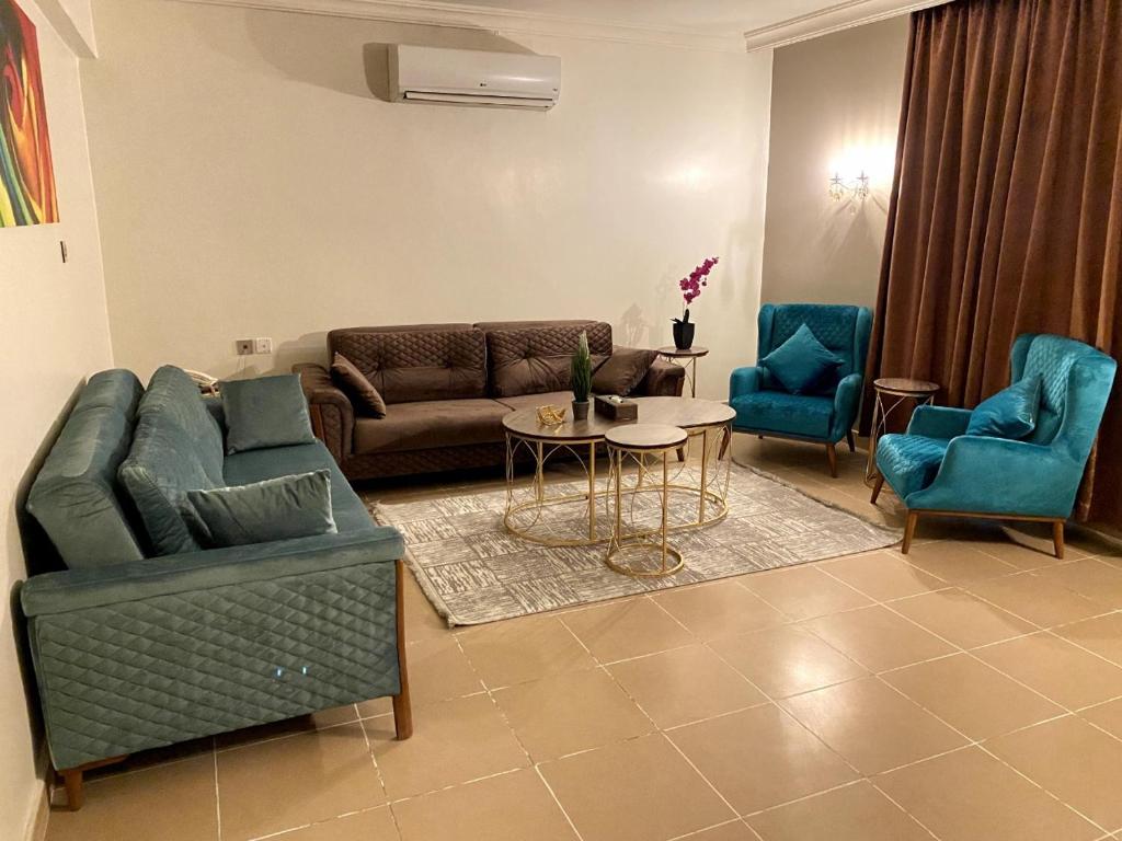 a living room with couches and a table and chairs at Al Bustan Hotel Suites in Al Hofuf