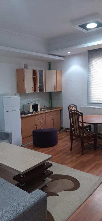 een kamer met een keuken en een tafel en stoelen bij Guesthouse Hadžići in Hadžići