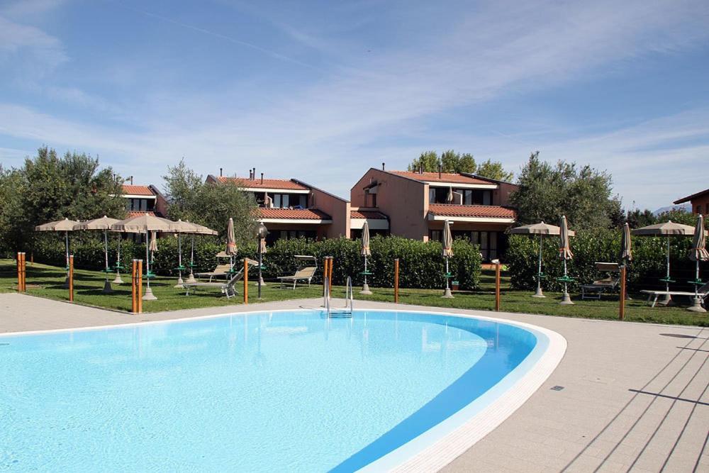 ein großer blauer Pool vor einem Haus in der Unterkunft Villaggio Barbara in Moniga