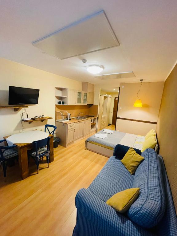 a room with a bed and a table and a kitchen at Studio Kris Villa Park in Borovets