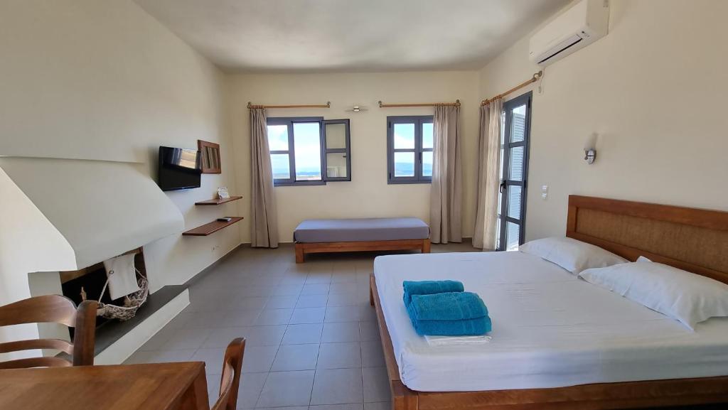 a bedroom with a bed and a table and a couch at Domatia me Thea in Elafonisos