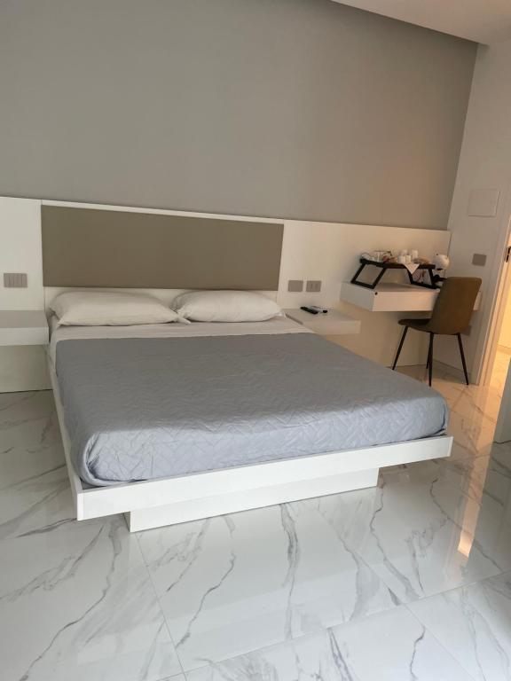 a bedroom with a white bed and a desk at B & B La casa di Bianca Luxury in Crotone
