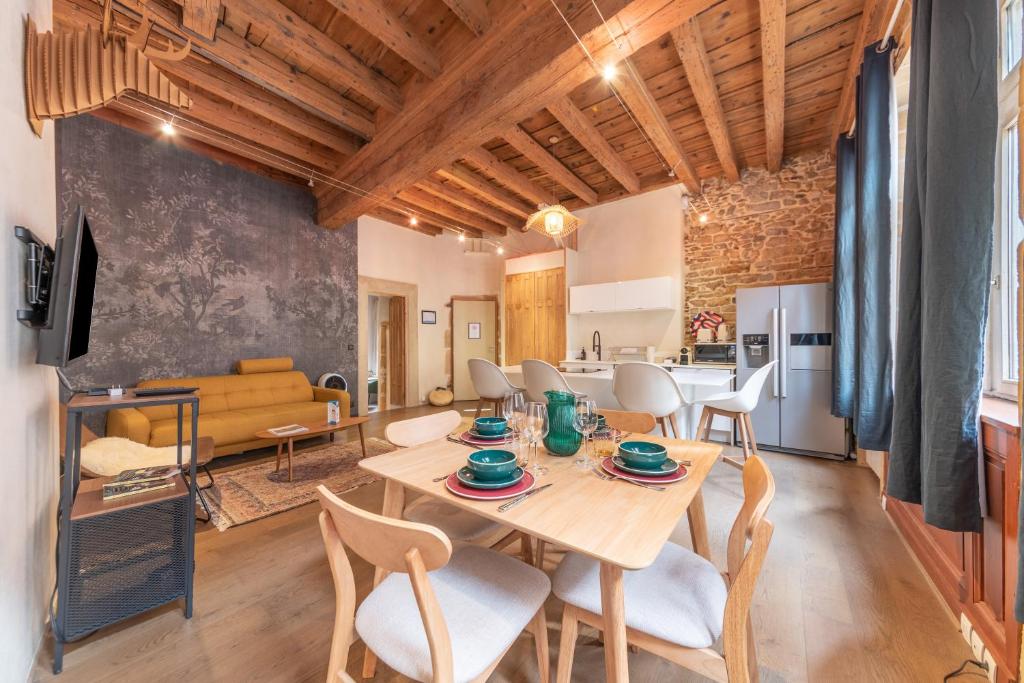 Un comedor y una sala de estar con mesa y sillas. en L'Authentique - au cœur de Lyon, en Lyon