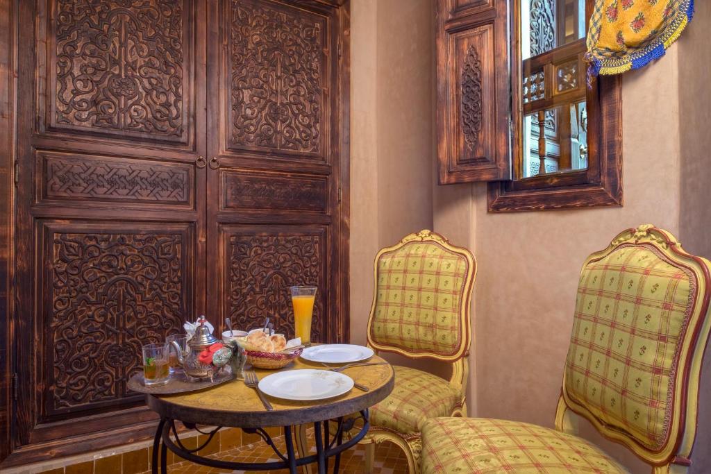 a dining room with a table and two chairs at dar al walidine in Marrakesh