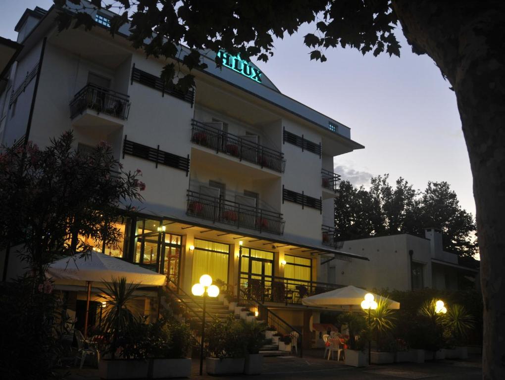 un edificio con un cartello illuminato di Hotel Lux a Cesenatico