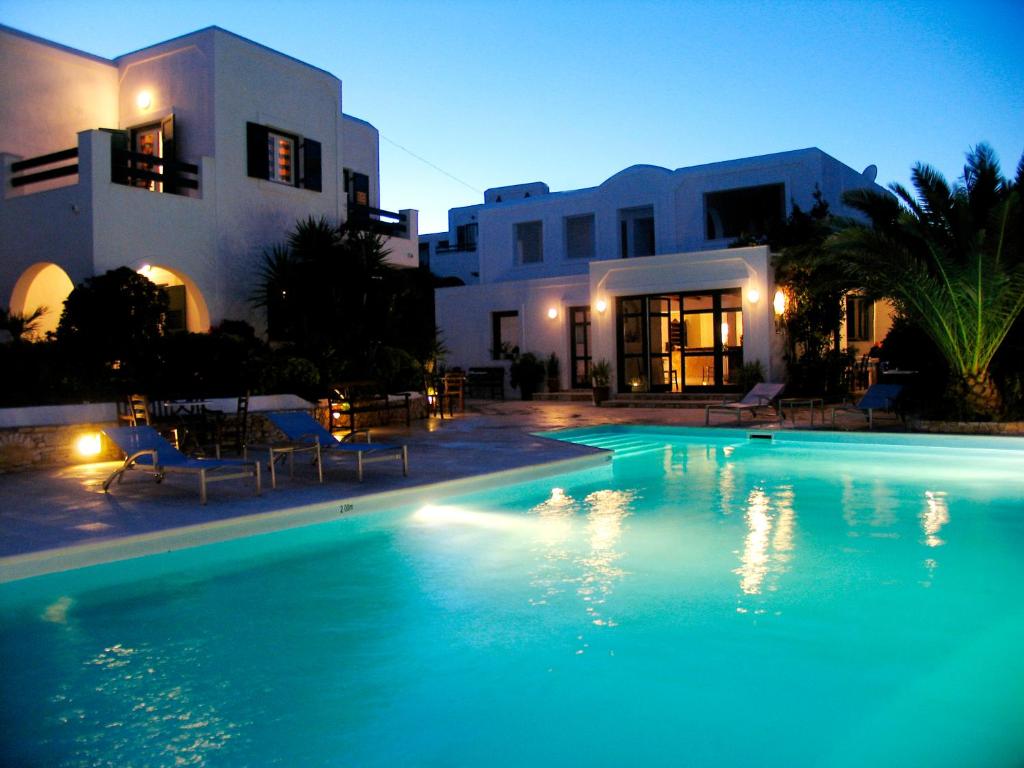 a swimming pool in front of a house at night at Keros Art Hotel in Koufonisia