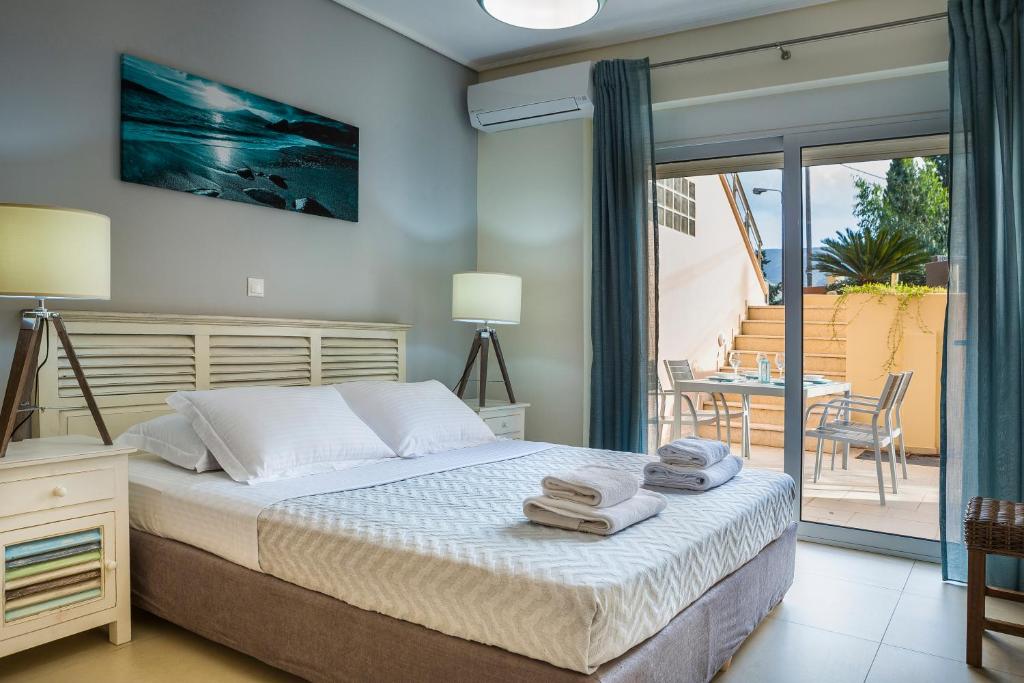 a bedroom with a bed and a balcony with a table at Apartment Lilly, brand new apartment with communal pool, 10 meters from sea in Sami
