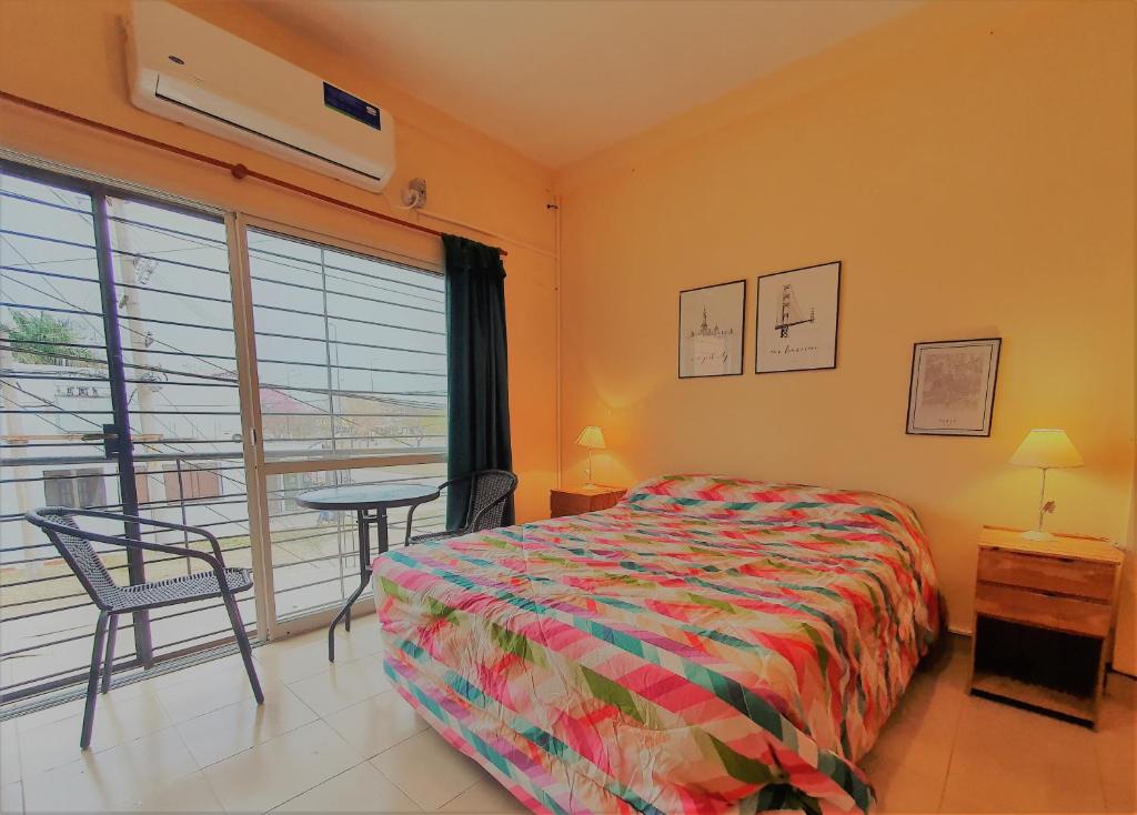 1 dormitorio con cama, mesa y ventana en B3 Apartments en Formosa