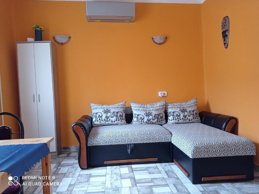 uma cama num quarto com uma parede laranja em BORINA VENDÉGHÁZ em Sátoraljaújhely