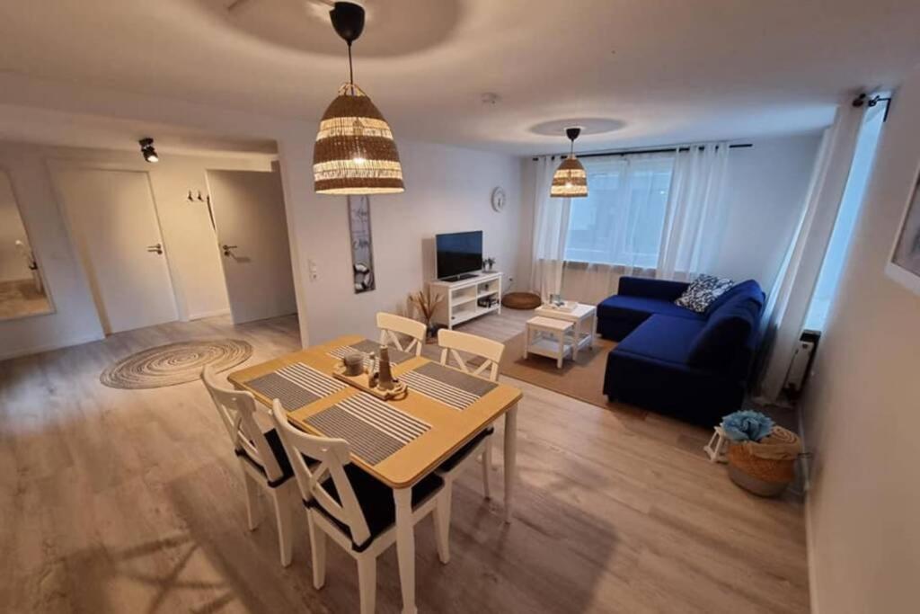 een woonkamer met een tafel en een blauwe bank bij Ferienwohnung Elwetritsch an der Nordsee in Ihlienworth