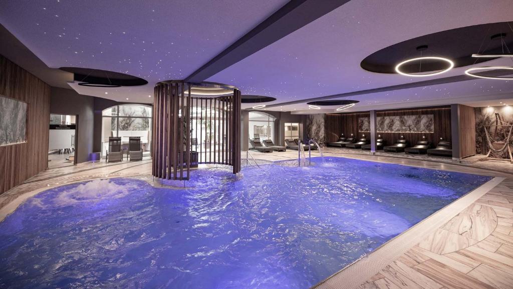 - une grande piscine bleue au milieu d'une pièce dans l'établissement Hotel Almesberger, à Aigen im Mühlkreis