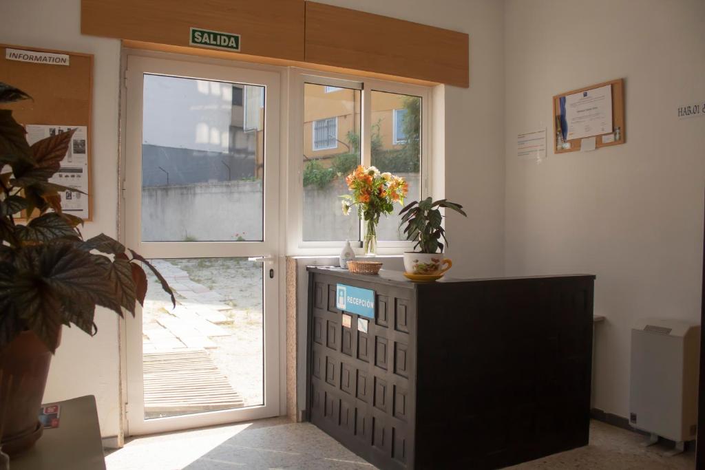 um quarto com uma porta com uma planta e uma televisão em Albergue Santa Olaia em Silleda
