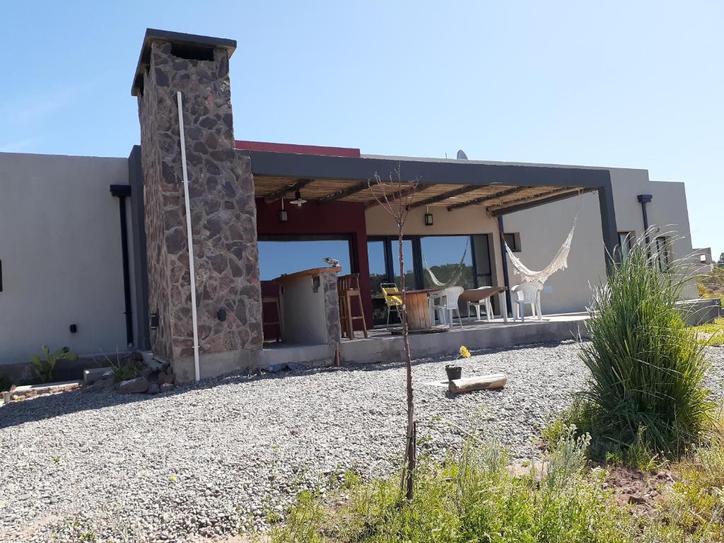 ein Haus mit einer Steinsäule davor in der Unterkunft sueño del chocon in Villa El Chocón