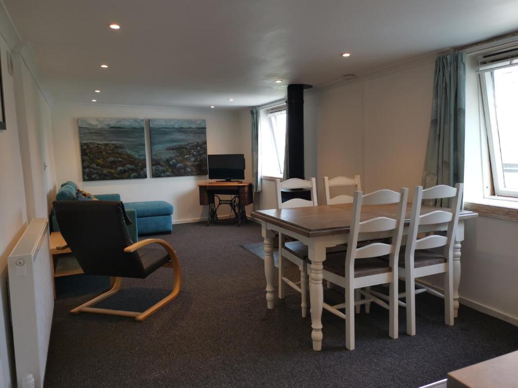 een woonkamer met een eettafel en stoelen bij Relax in a 1 Bedroom Apartment near a country Pub in Eyemouth