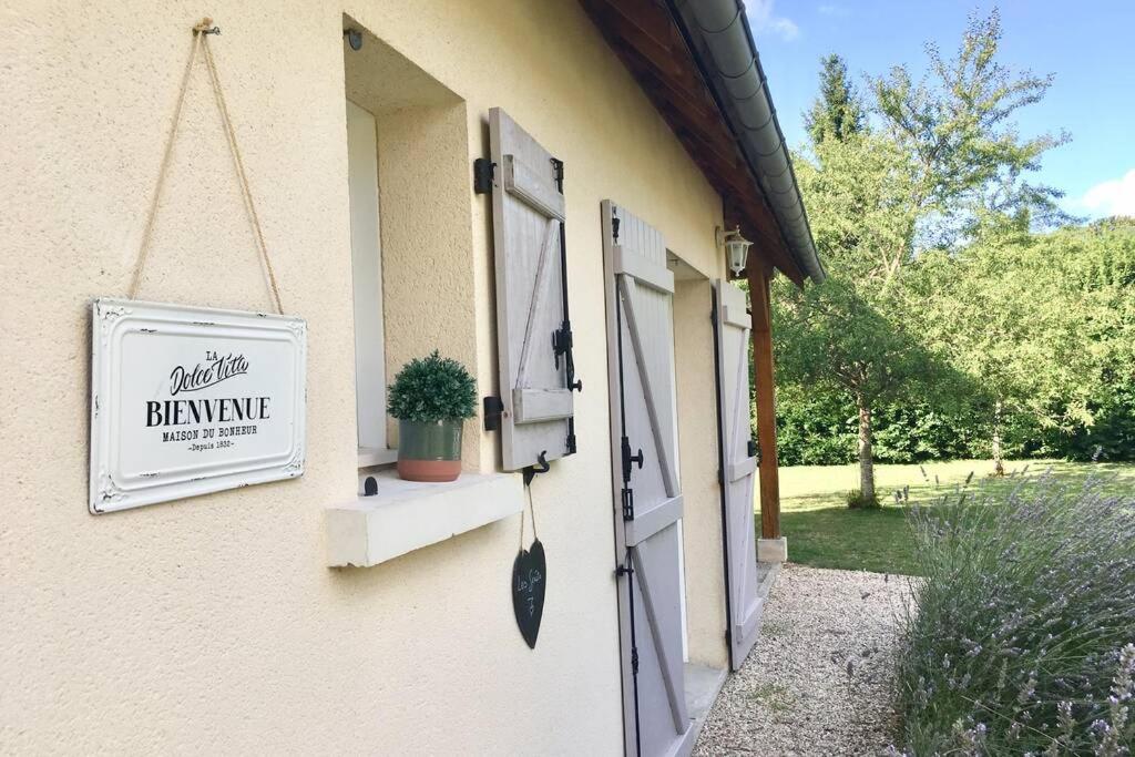 ein Schild an der Seite eines Hauses mit Fenster in der Unterkunft Les Genêts in Fontaine-sous-Jouy