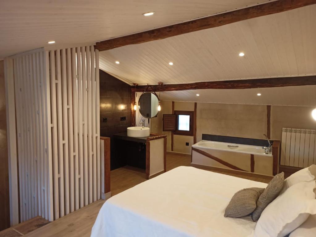- une chambre avec un lit, un lavabo et une baignoire dans l'établissement La Herrerita, à Candelario