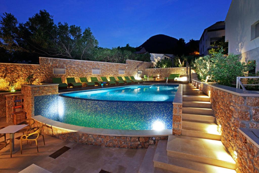 a swimming pool in a backyard at night at Boutique Hotel Bol in Bol