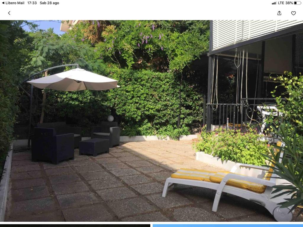 patio con panchina e ombrellone di Appartamento Leo a Paestum