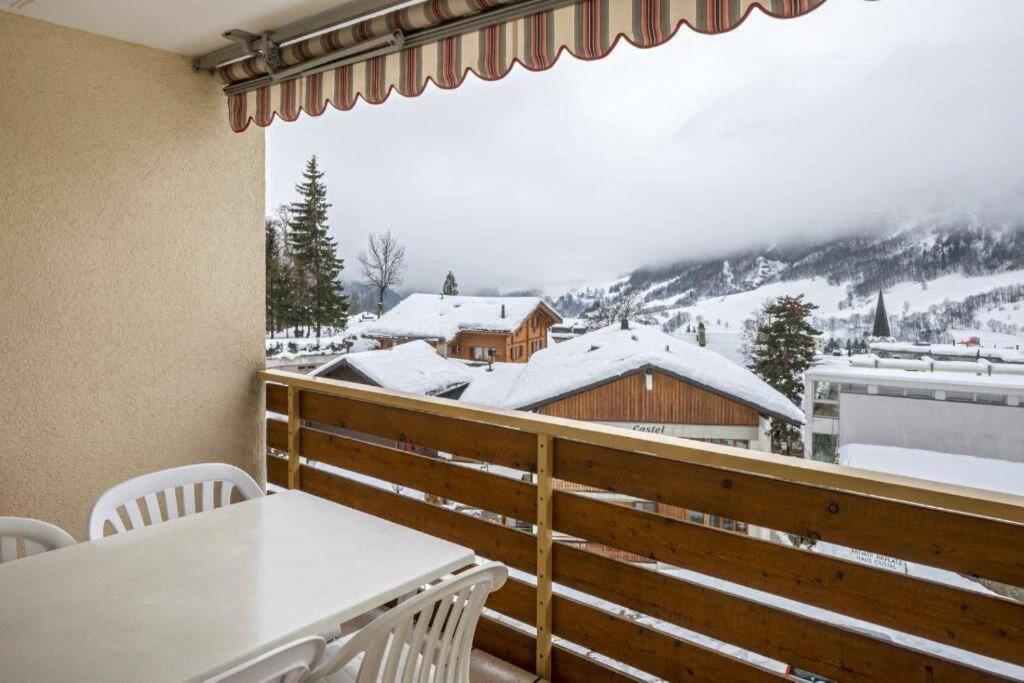 d'un balcon avec une table, des chaises et une montagne enneigée. dans l'établissement Cristal 50, à Loèche-les-Bains