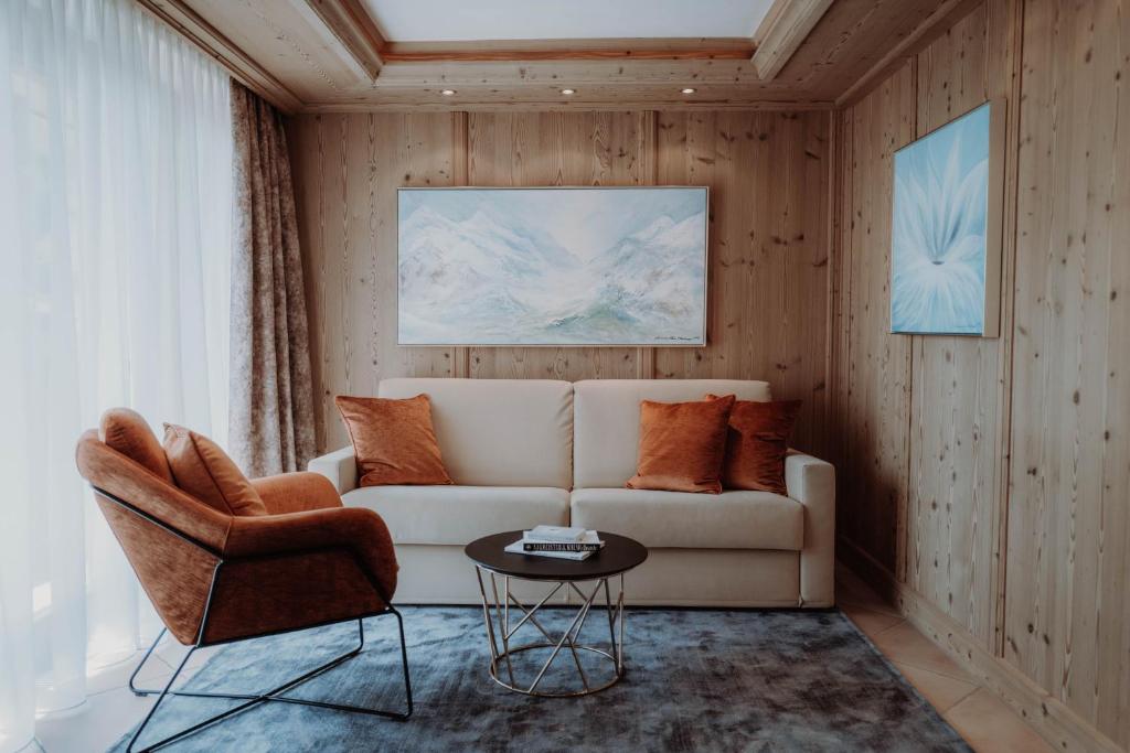 sala de estar con sofá y silla en Das Verwall - finest serviced apartments, en Lech am Arlberg