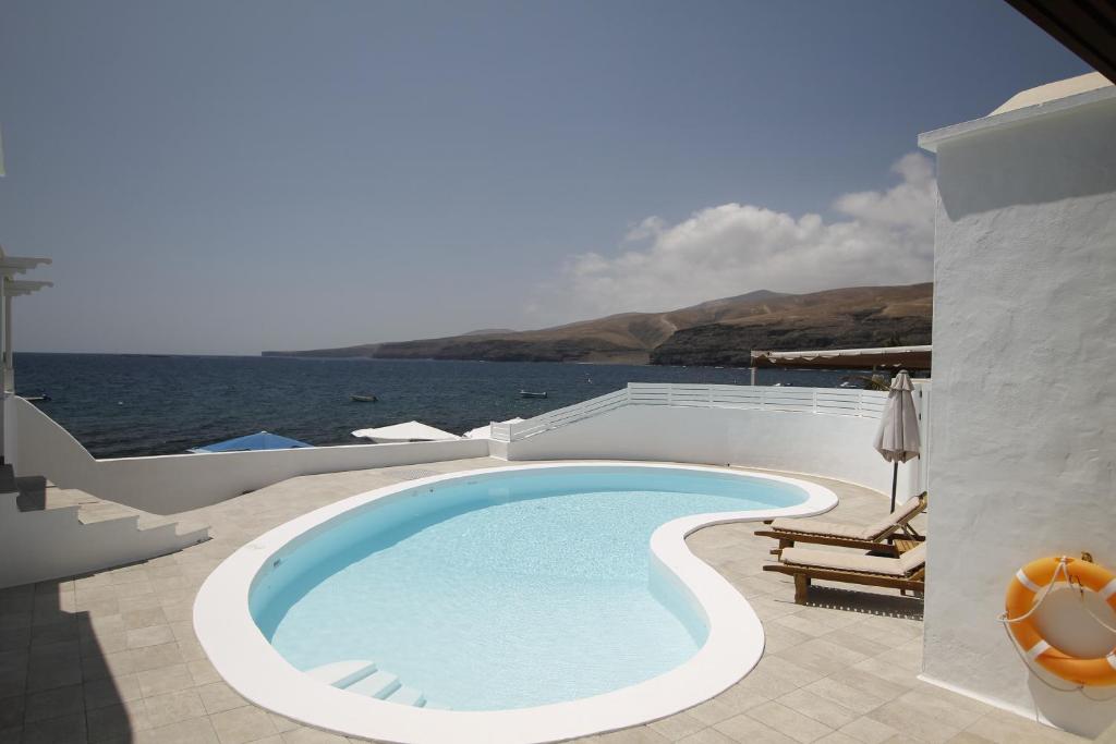 una piscina en un patio junto al agua en Playa Quemada, en Playa Quemada