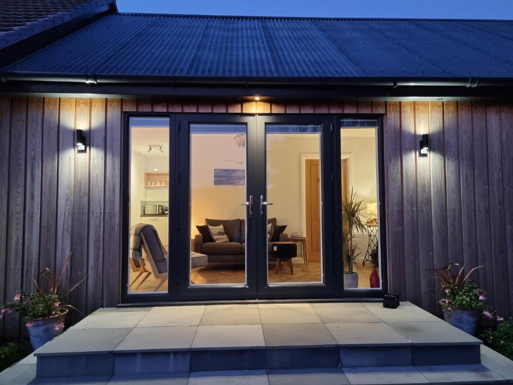 une chambre avec des portes coulissantes en verre sur une maison dans l'établissement Glenfalloch Beag Apartment, Torvaig, à Portree