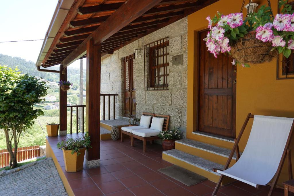 un porche de una casa con escaleras y flores en Leiras do Seixo - Casa dos Tinos, en Amarante