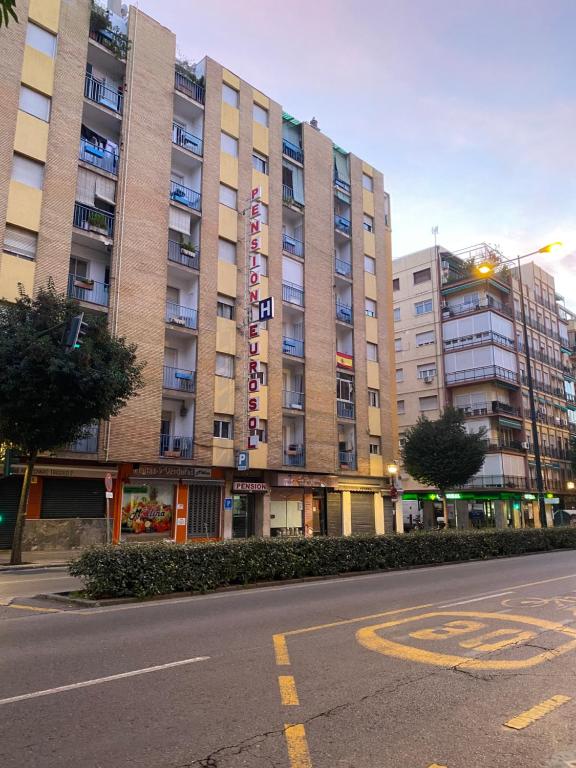 una calle vacía frente a un gran edificio en Pensión Eurosol, en Granada