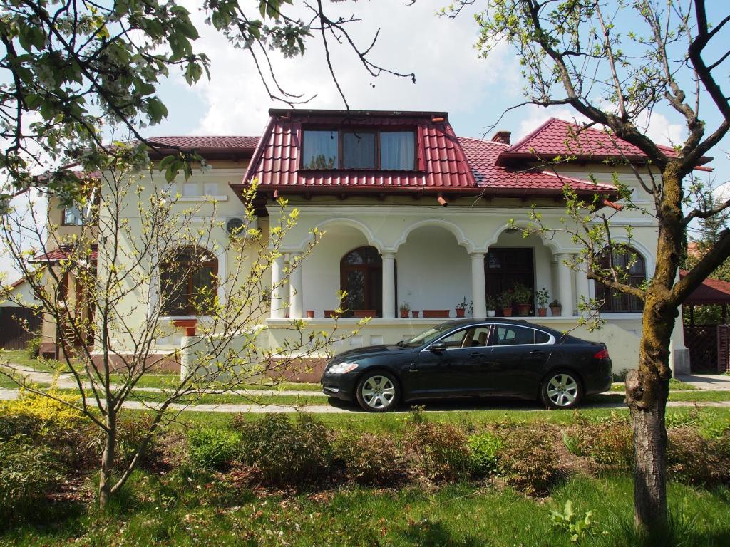 a black car parked in front of a house at Argeselu Garden Villa-entire floor apartment, exclusive garden access in Mărăcineni