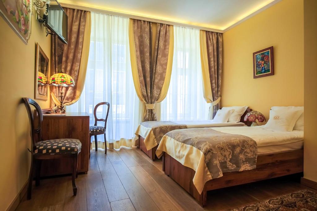 Una habitación de hotel con dos camas y una ventana. en Aparthotel Grodzka 21, en Cracovia