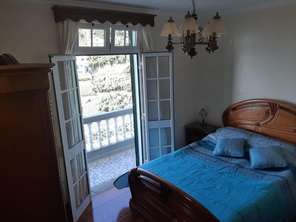 1 dormitorio con 1 cama y puerta abierta en Casa do Terço, en Câmara de Lobos