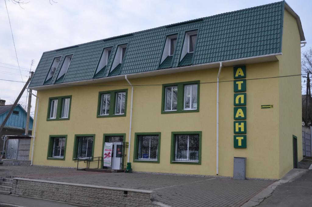 ein gelbes Gebäude mit einem Schild an der Seite in der Unterkunft Atlant Hotel in Ostroh