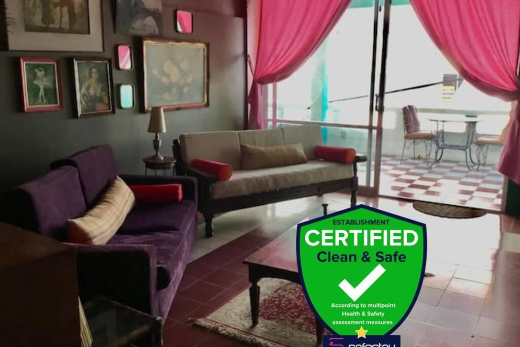 a living room with purple furniture and a sign that says certified clean and safe at My Lovely Loft Beach RG3 in Puerto Vallarta