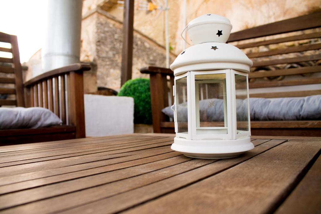 una lanterna bianca seduta sopra un tavolo di legno di CALA VELLA Casa Vacacional RURAL a Bocairent